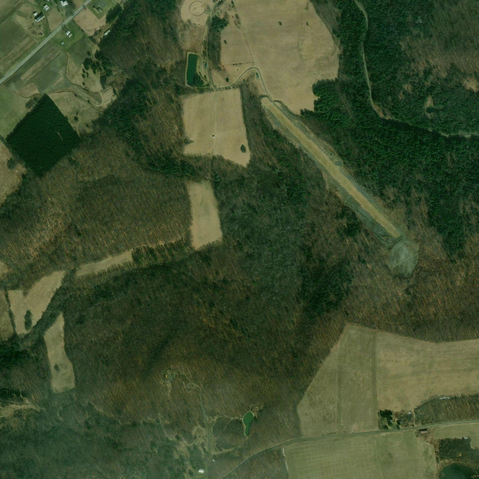 Summer satellite of the property: hayfields, a conifer draw and full-canopy hardwood ridges.